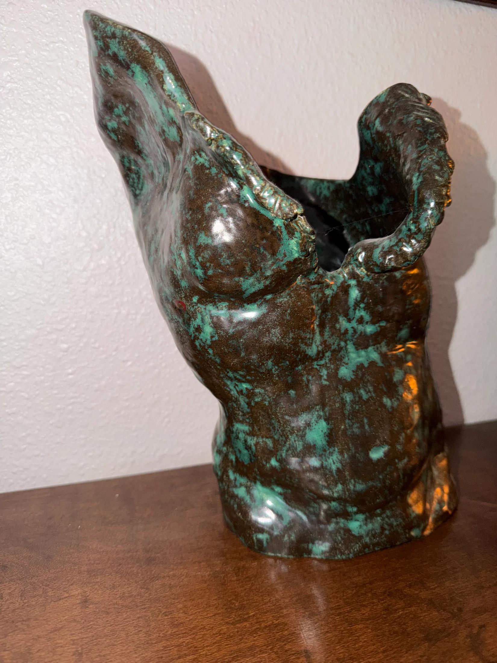 Patinated figurative sculpture by Sel Tasteme viewed from one side.